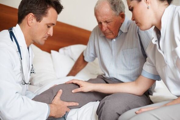 Arzt untersucht Knie des Patienten